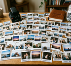 Collection of Polaroid photos and a camera on a wooden table, made by Kustomade, India