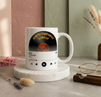 White mug with vinyl record design and 'Happy Birthday Shelly' text on a marble coaster.
